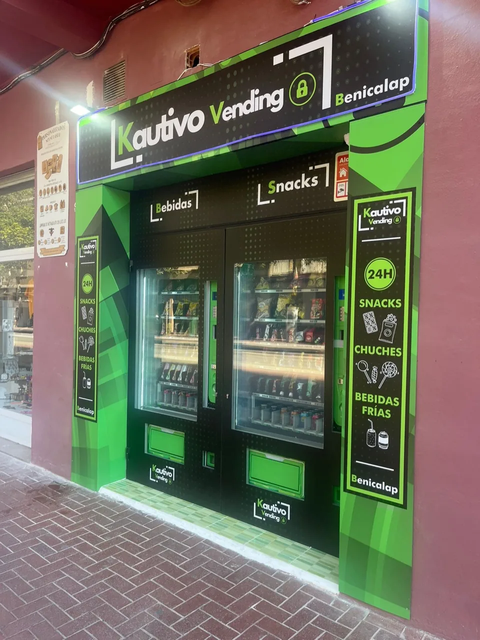 Instalación real de Kautivo Vending en un local a pie de calle, con máquinas de bebidas y snacks y rótulo iluminado
