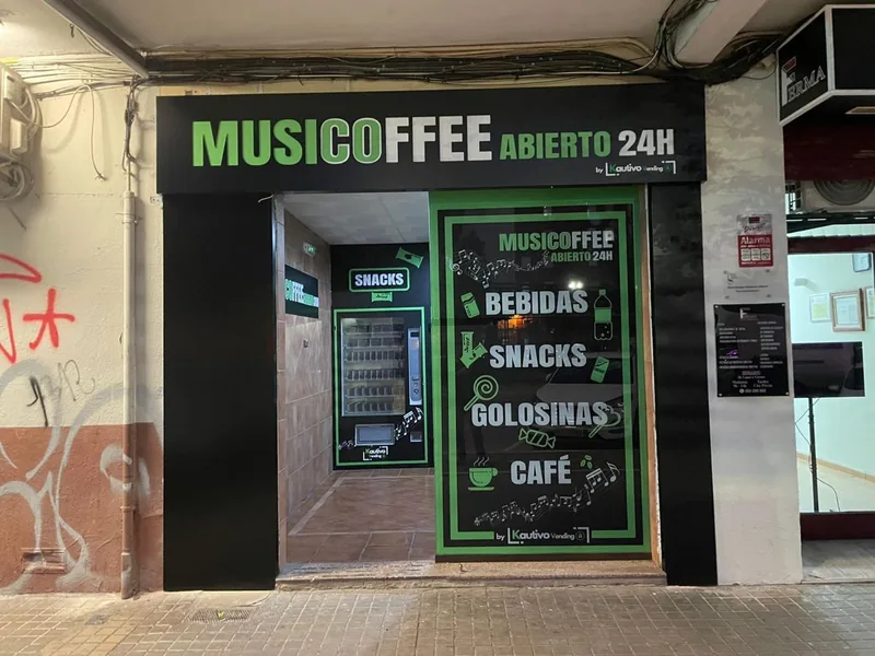 Entrada de una tienda automática 24 h con máquinas en el interior, vista desde la calle